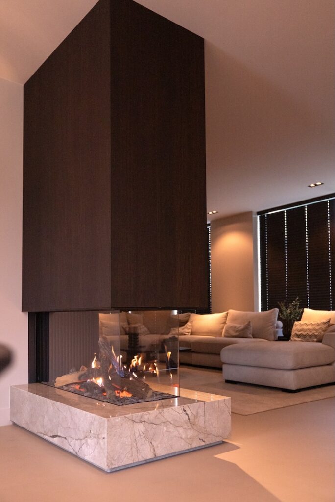 Moderne gashaard in luxe interieur met gietvloer, marmer en donker hout